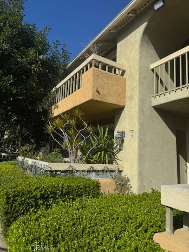 view of property exterior with a balcony and stucco siding