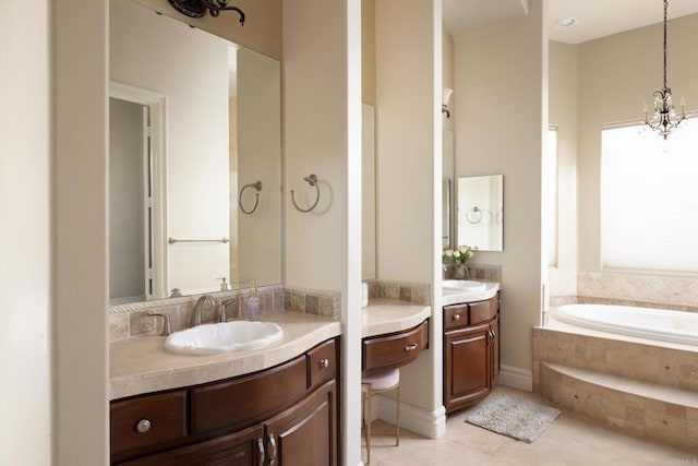 full bathroom featuring a garden tub, two vanities, a sink, a chandelier, and tile patterned floors