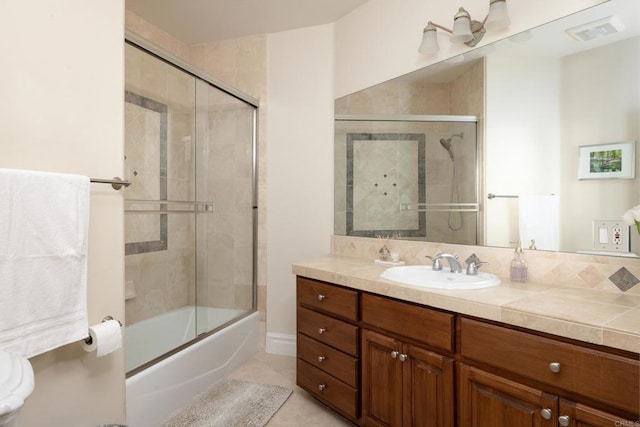 bathroom featuring tile patterned flooring, visible vents, combined bath / shower with glass door, and vanity