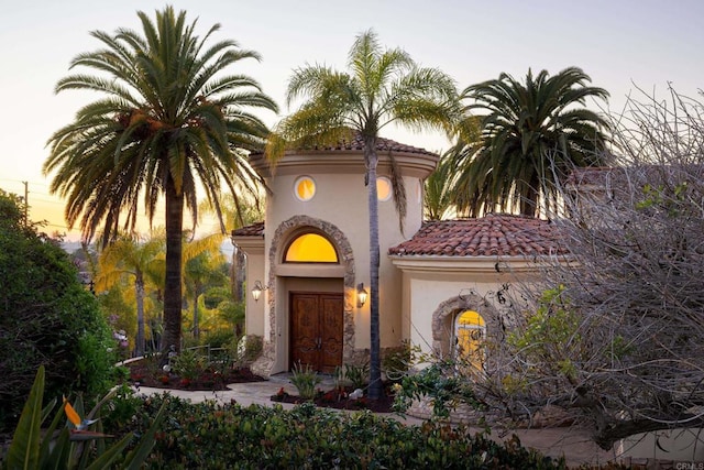 view of front of property with a tile roof and stucco siding