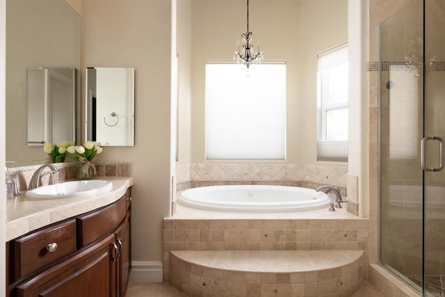 bathroom with a stall shower, a chandelier, a bath, and vanity