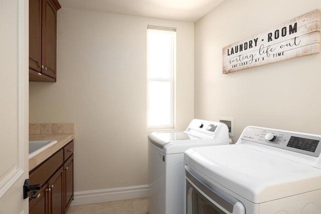 laundry room with cabinet space, light tile patterned flooring, a sink, independent washer and dryer, and baseboards