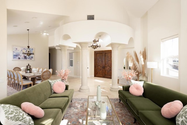 living area featuring high vaulted ceiling, arched walkways, visible vents, and ornate columns