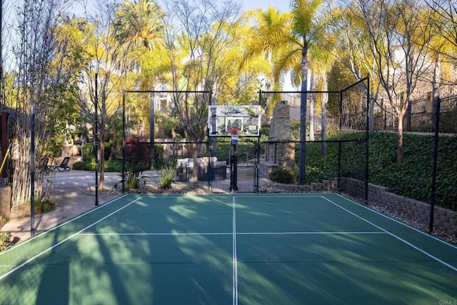 view of sport court featuring basketball hoop and fence