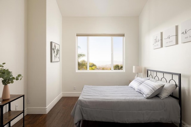 bedroom featuring dark wood-style flooring and baseboards