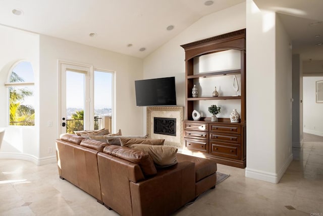 living area featuring vaulted ceiling, baseboards, and a premium fireplace