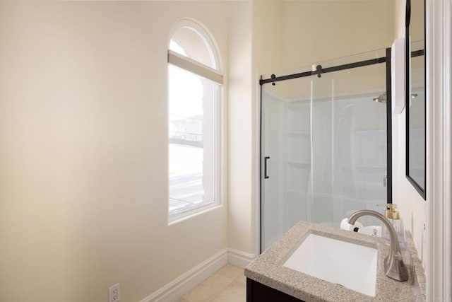 bathroom featuring baseboards, vanity, and a shower stall