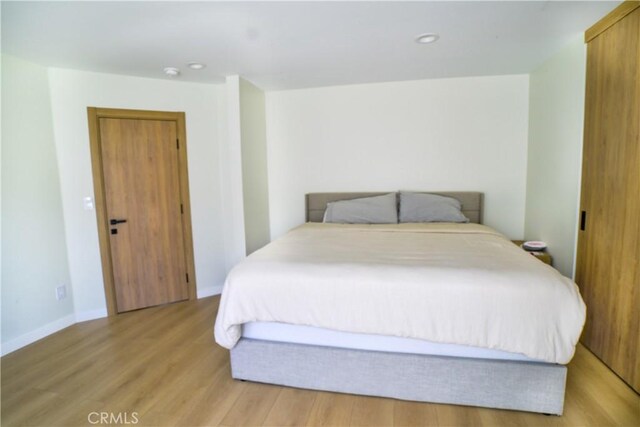 bedroom featuring light wood-type flooring, baseboards, and recessed lighting