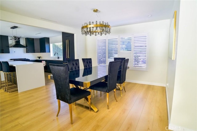 dining space with light wood-type flooring, baseboards, and an inviting chandelier