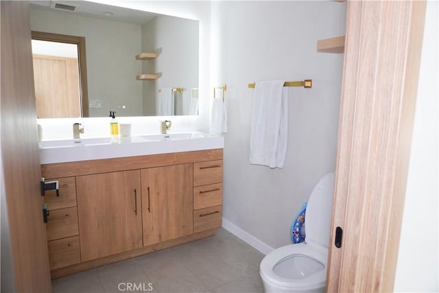 bathroom featuring tile patterned flooring, toilet, vanity, visible vents, and baseboards