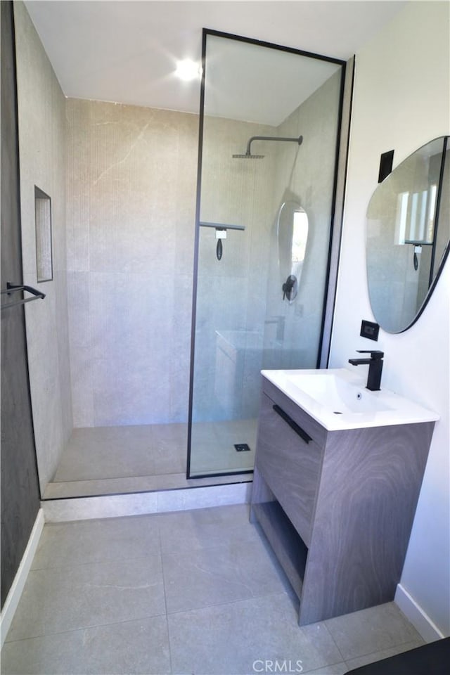 full bath with tiled shower, tile patterned flooring, and vanity