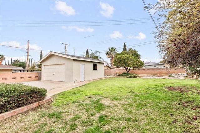 view of yard with a garage, fence, and an outdoor structure