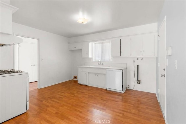 kitchen featuring light wood finished floors, custom exhaust hood, gas stove, a sink, and dishwasher