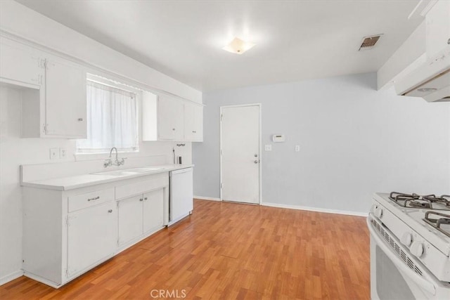 kitchen featuring white appliances, a sink, visible vents, light countertops, and light wood-type flooring