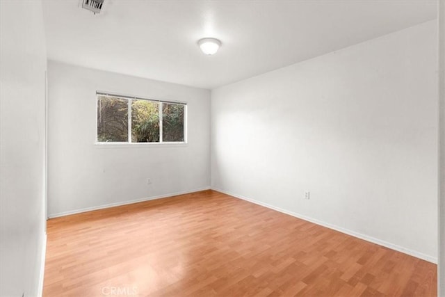 unfurnished room featuring light wood finished floors and baseboards