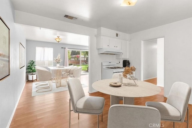 dining room with visible vents, light wood-style flooring, and baseboards