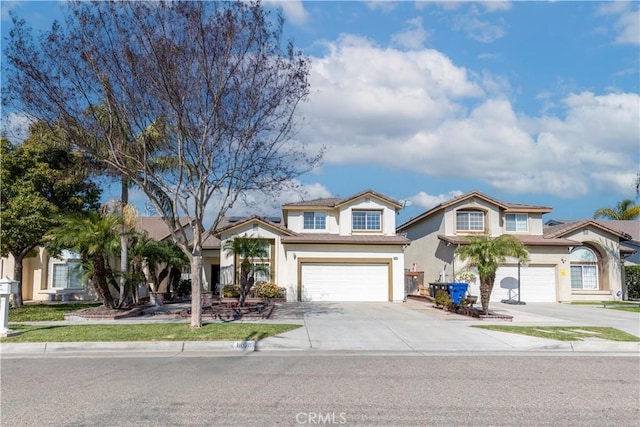 traditional home featuring a garage, concrete driveway, and stucco siding