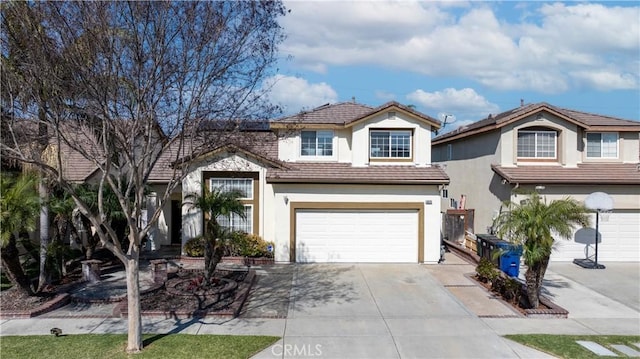 view of front of property featuring a tile roof, driveway, an attached garage, and stucco siding