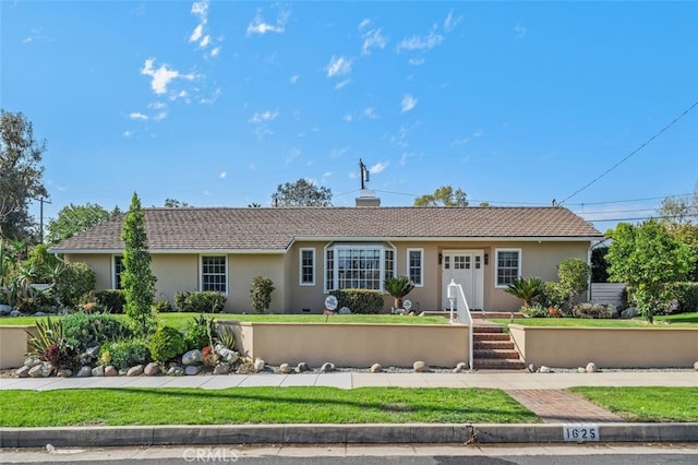 ranch-style house featuring a chimney and stucco siding