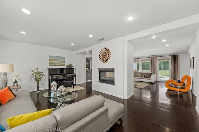 living room with a multi sided fireplace, wood finished floors, visible vents, and recessed lighting