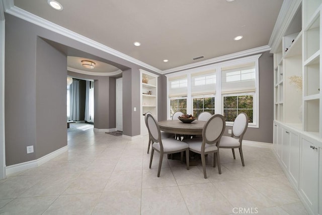 dining area featuring ornamental molding, light tile patterned flooring, visible vents, and baseboards