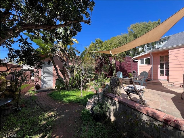 view of yard with an outbuilding, a patio area, and fence