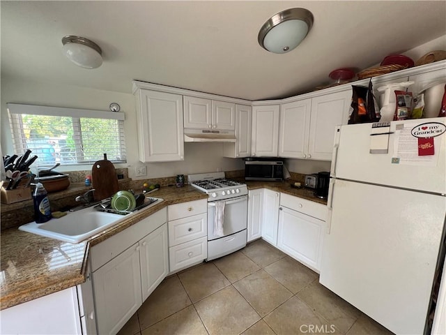 kitchen with light tile patterned floors, under cabinet range hood, white appliances, a sink, and white cabinetry