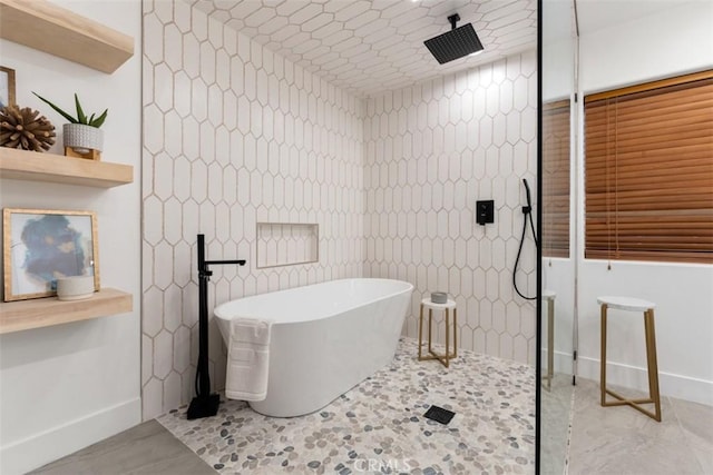 full bath featuring a walk in shower, tile patterned flooring, a freestanding tub, and tile walls