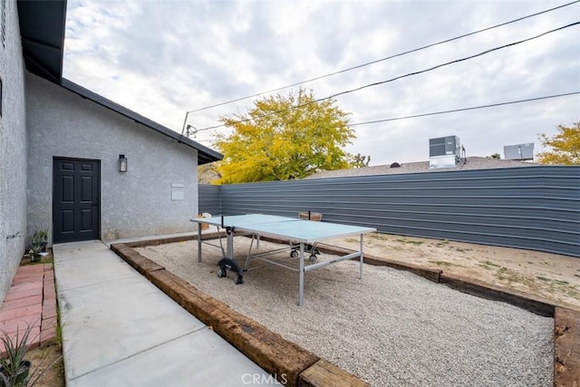 view of yard with central air condition unit and a patio