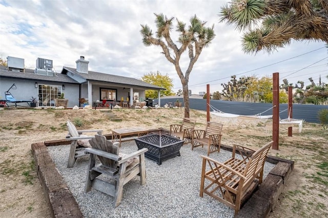 exterior space featuring an outdoor fire pit and central AC unit