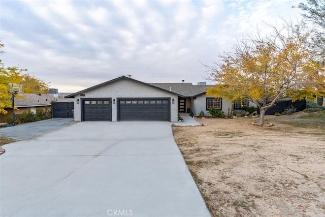 ranch-style home featuring a garage, concrete driveway, and stucco siding