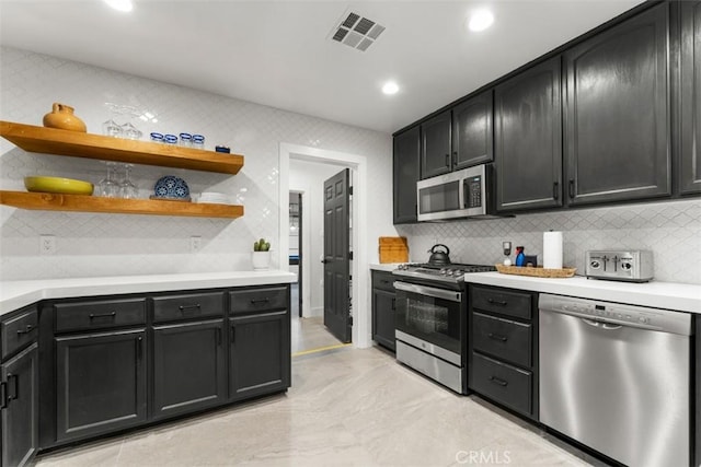 kitchen with open shelves, appliances with stainless steel finishes, visible vents, and dark cabinets