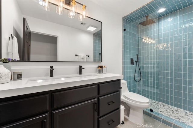 bathroom featuring a walk in shower, vanity, toilet, and tile patterned floors