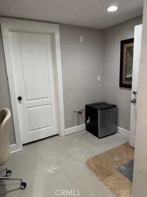 interior space featuring unfinished concrete floors, baseboards, and recessed lighting