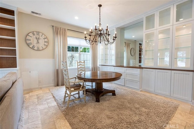 dining room with a chandelier, recessed lighting, stone tile floors, visible vents, and wainscoting