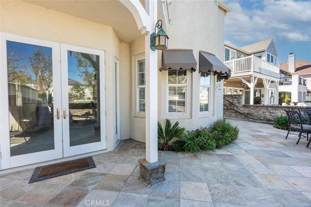 doorway to property with french doors, a patio, and stucco siding