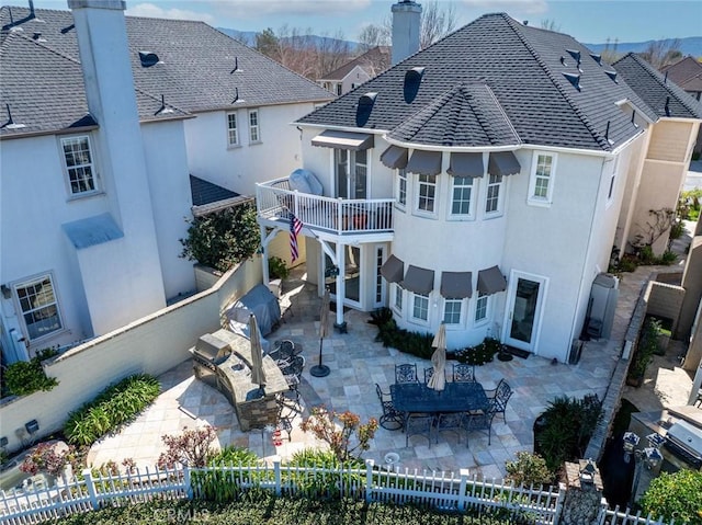 rear view of house with a fenced backyard and a patio