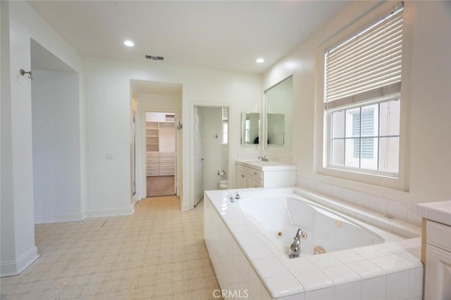 bathroom with toilet, recessed lighting, vanity, tile patterned floors, and a whirlpool tub