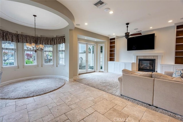 unfurnished living room featuring built in shelves, recessed lighting, visible vents, baseboards, and a glass covered fireplace