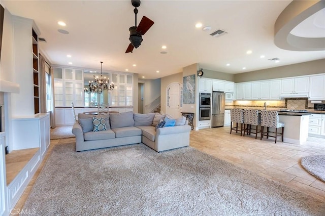 living area with stairway, ceiling fan with notable chandelier, visible vents, and recessed lighting