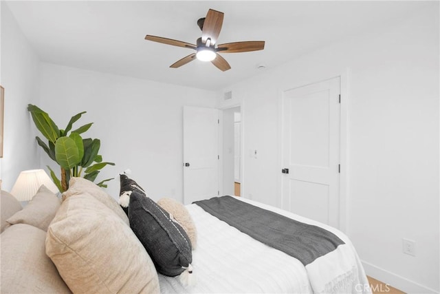 bedroom with baseboards, visible vents, and ceiling fan