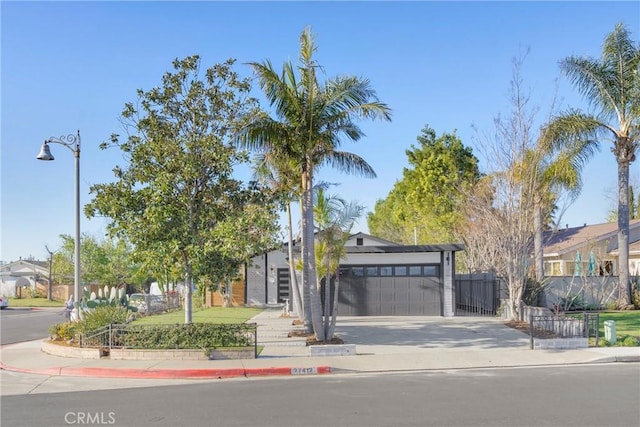 view of front of house featuring a garage, fence, and concrete driveway