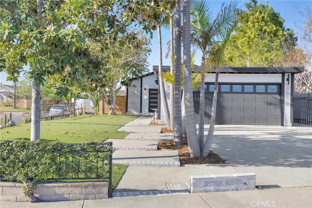 view of front facade featuring driveway, a garage, fence, and a front yard