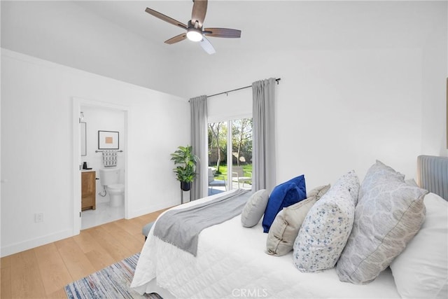 bedroom with lofted ceiling, a ceiling fan, connected bathroom, wood finished floors, and baseboards