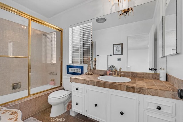full bath featuring vanity, crown molding, tile patterned flooring, toilet, and bath / shower combo with glass door