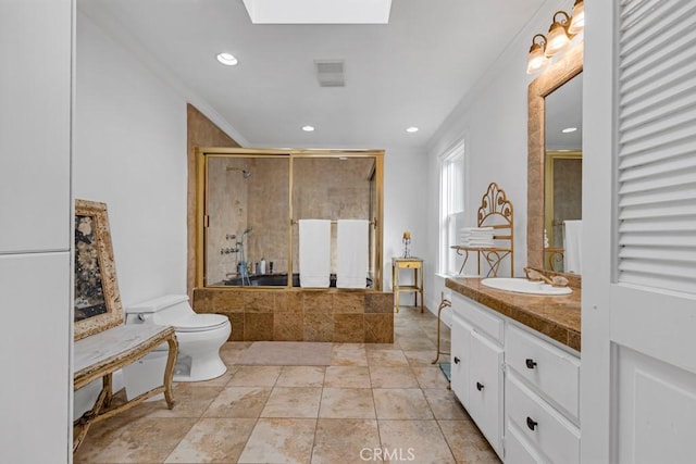 full bathroom featuring vanity, toilet, tiled shower, recessed lighting, and a skylight