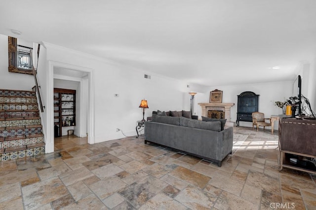 living room featuring stone tile floors, visible vents, stairway, and a fireplace