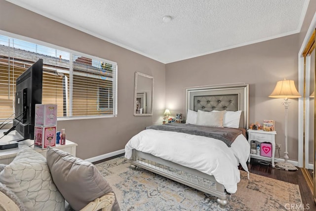 bedroom featuring baseboards, a textured ceiling, and wood finished floors