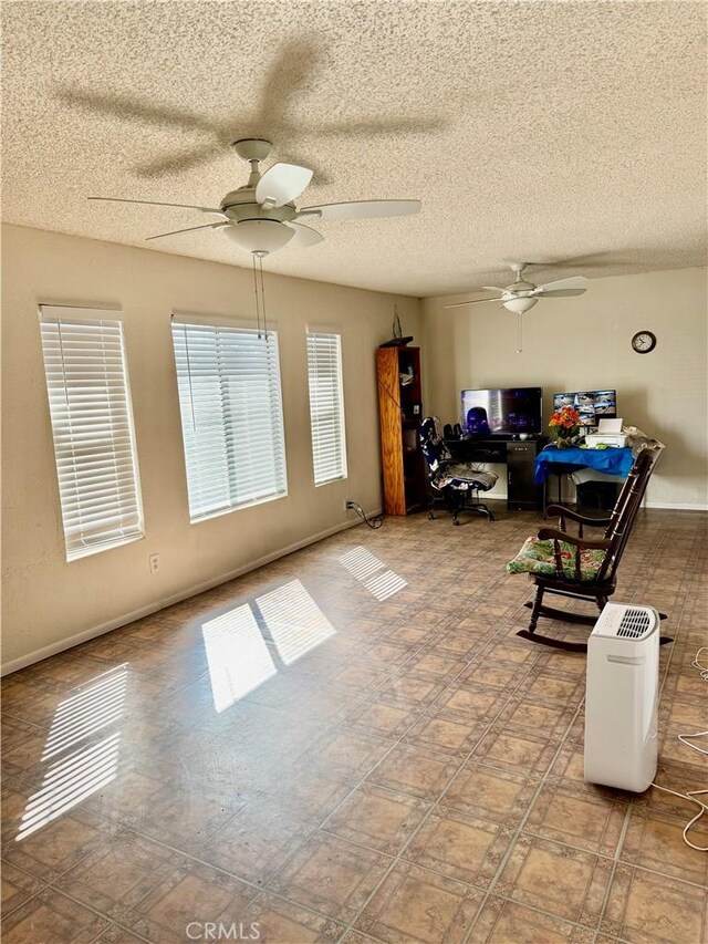 interior space with ceiling fan and a textured ceiling