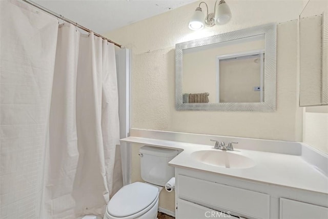 full bath with a textured wall, vanity, toilet, and a shower with curtain